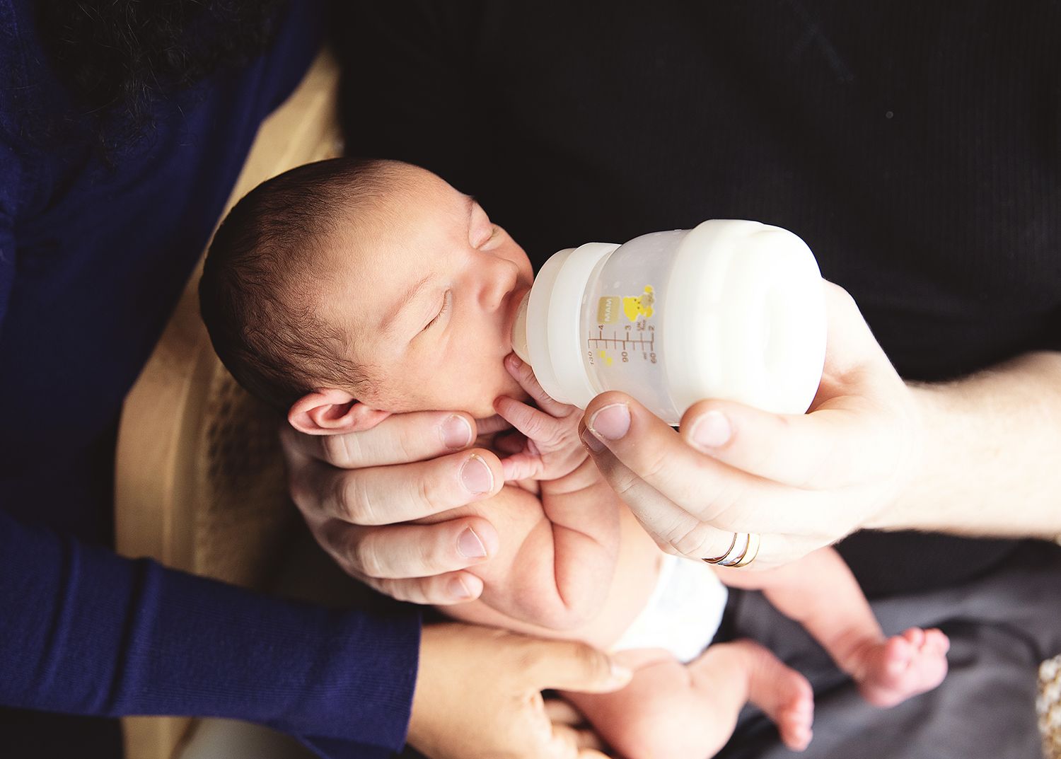 dad feeding baby before natural newborn photography session in London