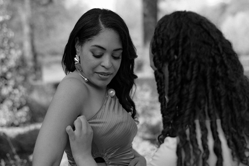 Ellisha Soanes personal branding photoshoot at the Christchurch mansion gardens in Ipswich. BTS image fixing up her dress, black and white