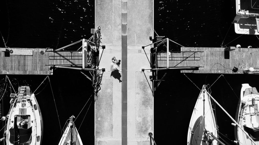 Two maintenance workers performing repairs on industrial scaffolding mounted to a tall concrete structure.