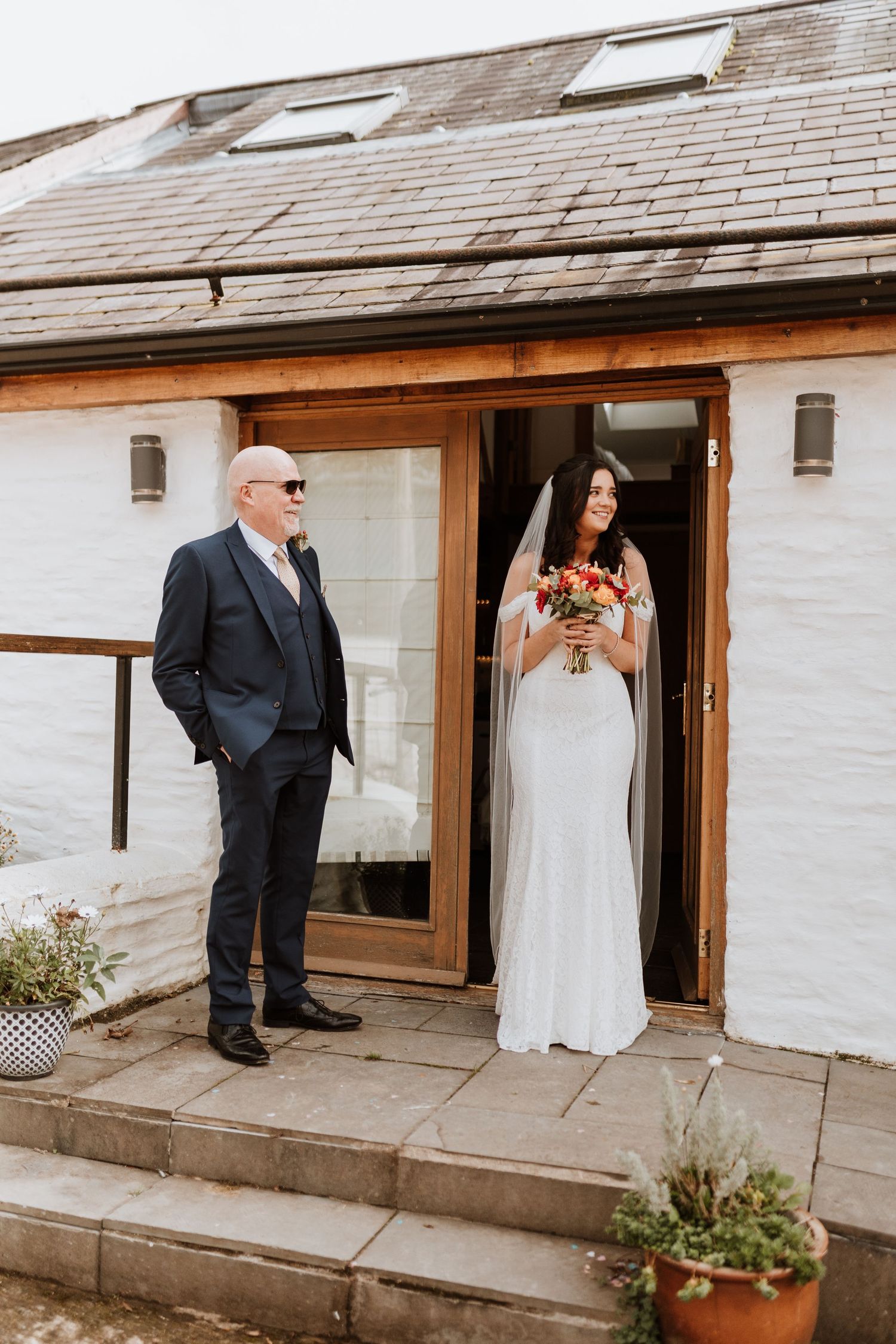 A sequence of five wedding photos showing a couple entering through a white brick building doorway.