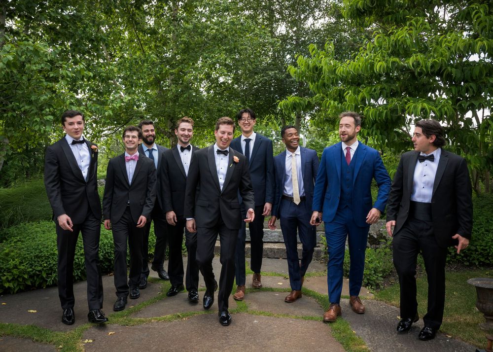 A group of groomsmen in formal suits and tuxedos pose together outdoors in various candid shots on wedding day.