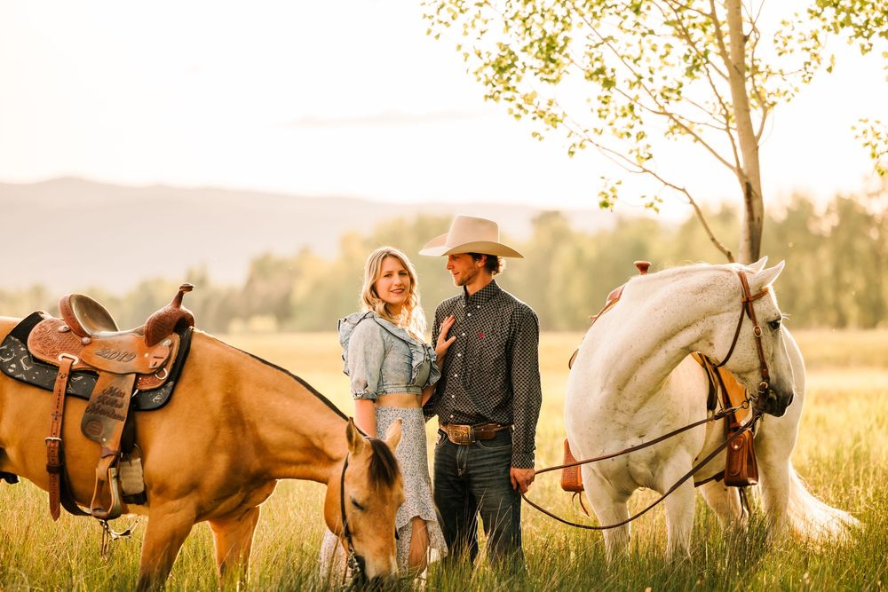 People enjoying a romantic sunset horseback ride along a rural trail in golden evening light.
