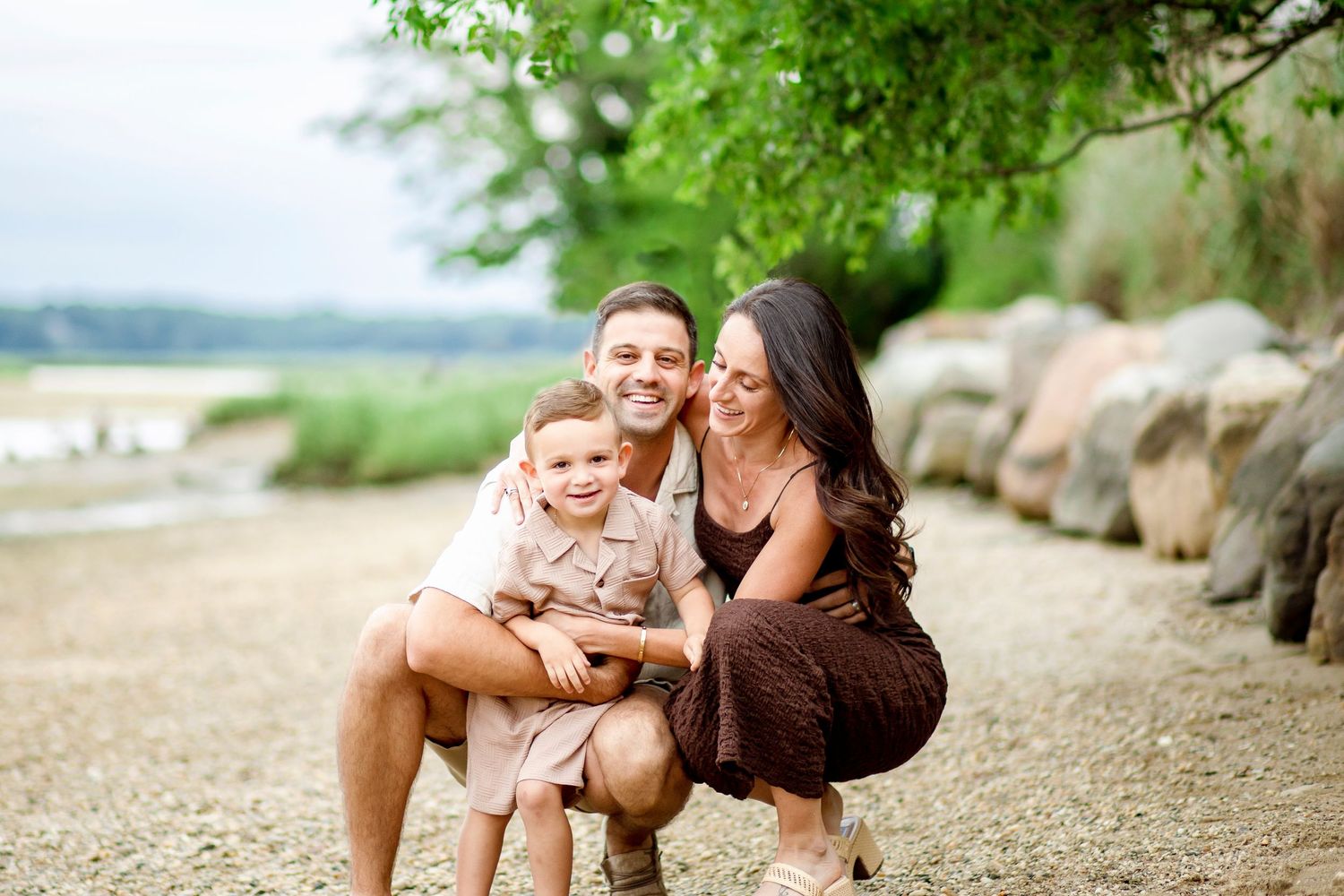 A romantic proposal scene set between rows of grapevines in a scenic vineyard with white flowers and a blanket.