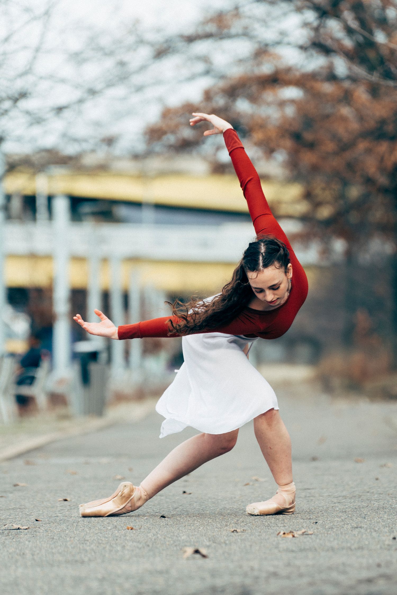 Dancer performing expressive choreography at golden hour with Pittsburgh bridges and rivers in the distance pittsburgh dance photography