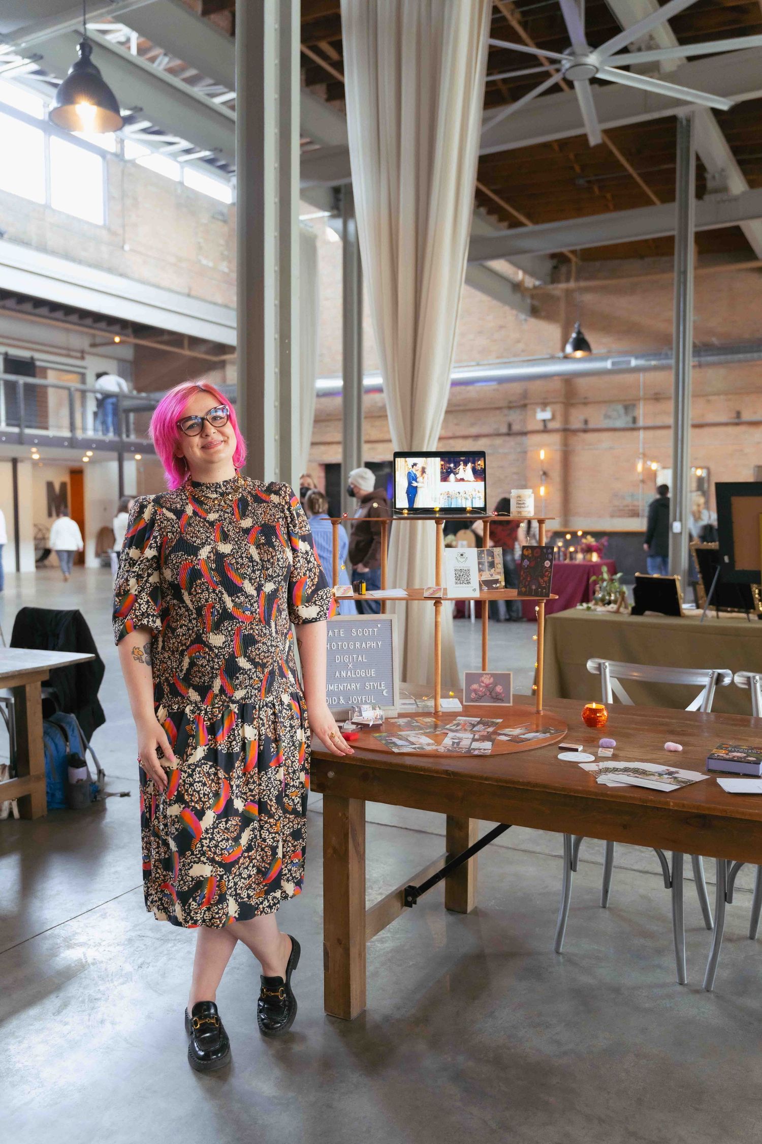 Creative event space showcases vendor displays with industrial architectural details and natural lighting. By FORGET ME NOT ARTS