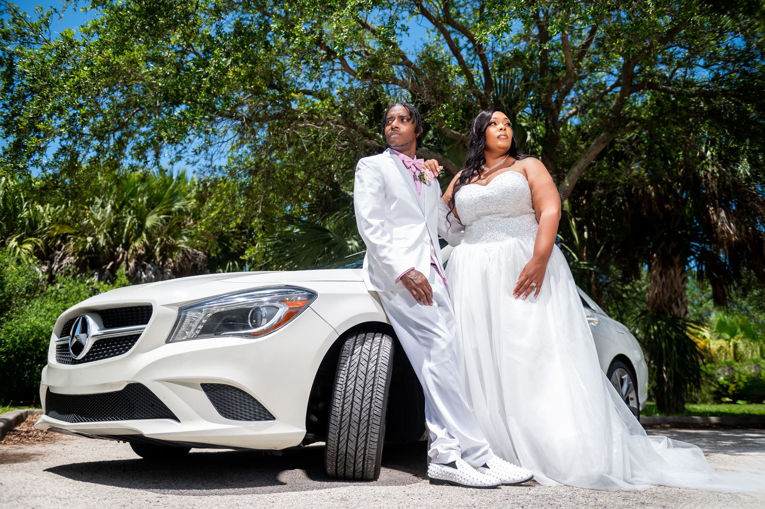 Bride and groom sharing a quiet moment in Wellington, garden venue, beautifully photographed in front of their luxury Mercedes-Benz.