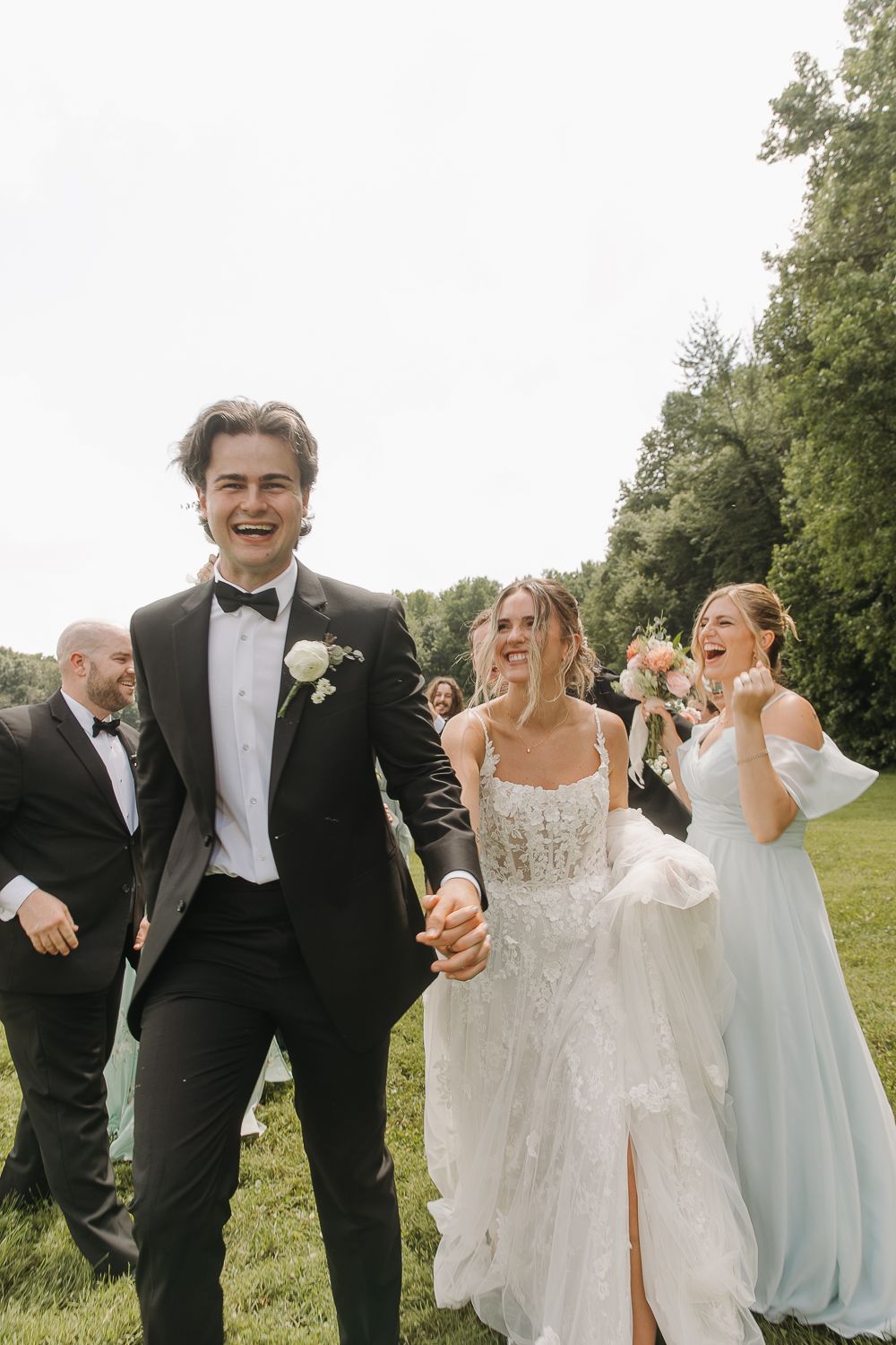 Candid photo series shows wedding party laughing together outdoors while walking in black tuxedos and light gowns.