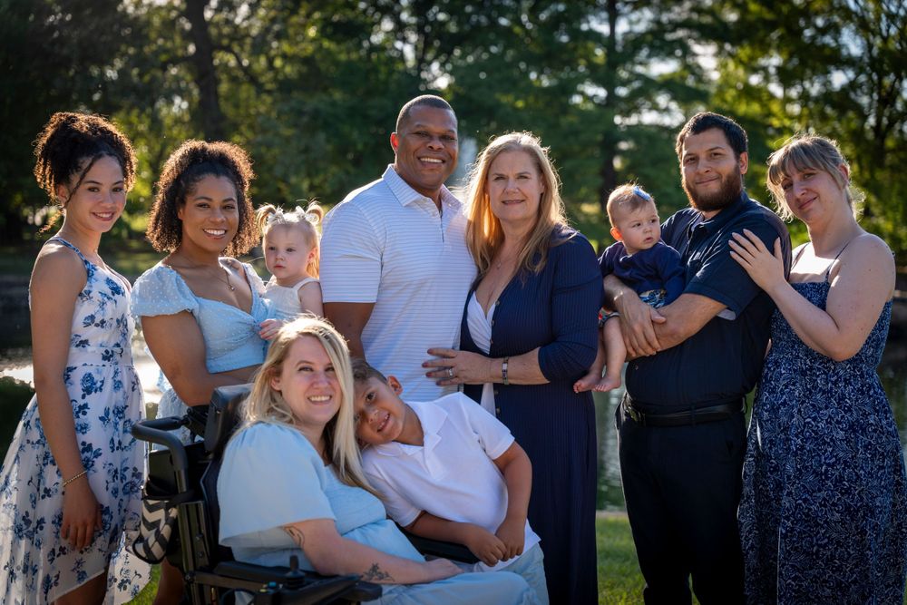 Friends and family members gather for a sunset portrait session in a park setting.