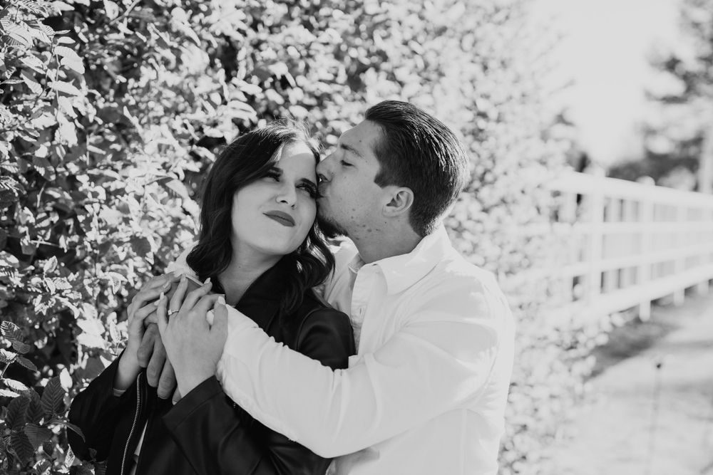 Black and white romantic portrait of couple sharing an intimate moment outdoors.