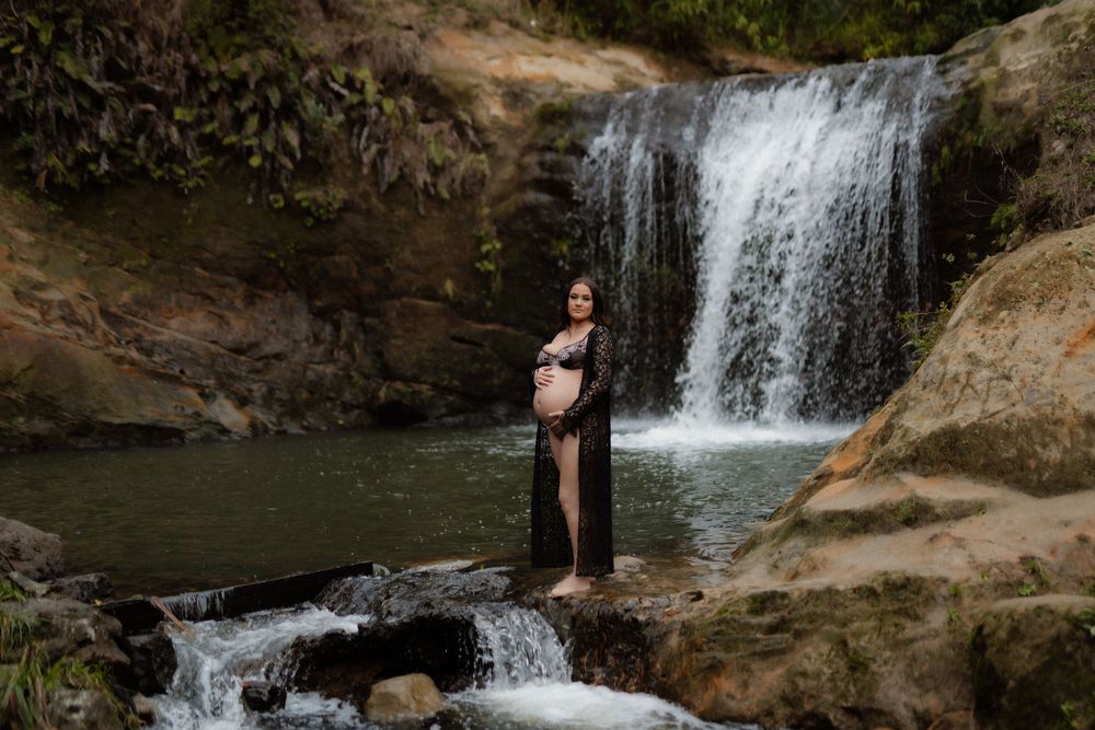 A person explores natural waterfalls and swimming holes surrounded by mossy rocks at Ozone Falls State Natural Area.