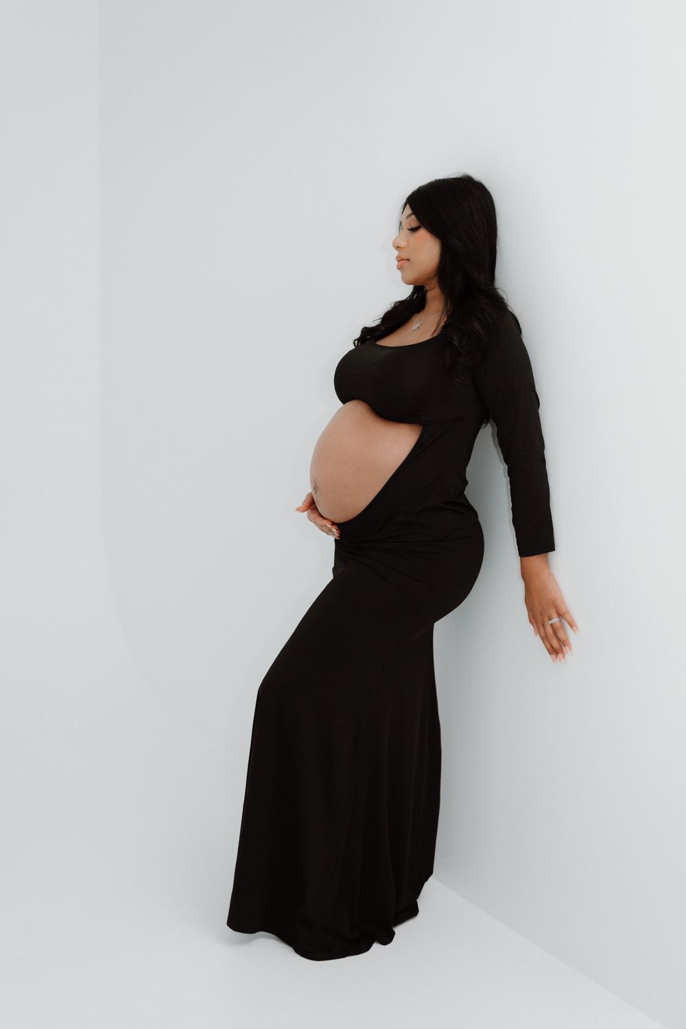 A woman in a black dress poses expressively against a white background in a series of dramatic shots.