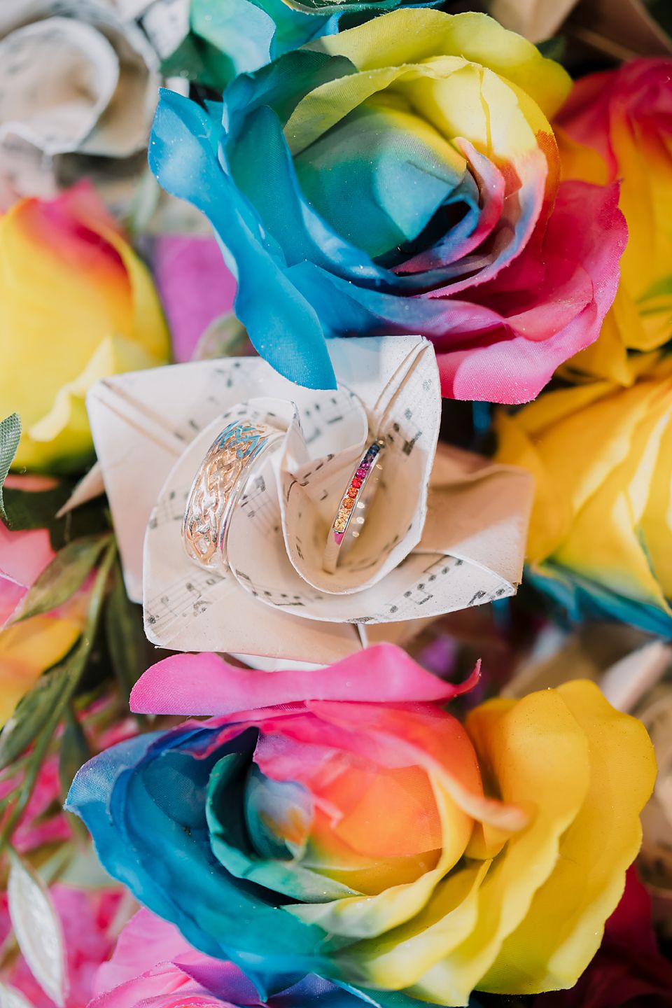 Colorful rainbow roses featuring vibrant shades of blue, yellow, pink and orange arranged in a decorative pattern.