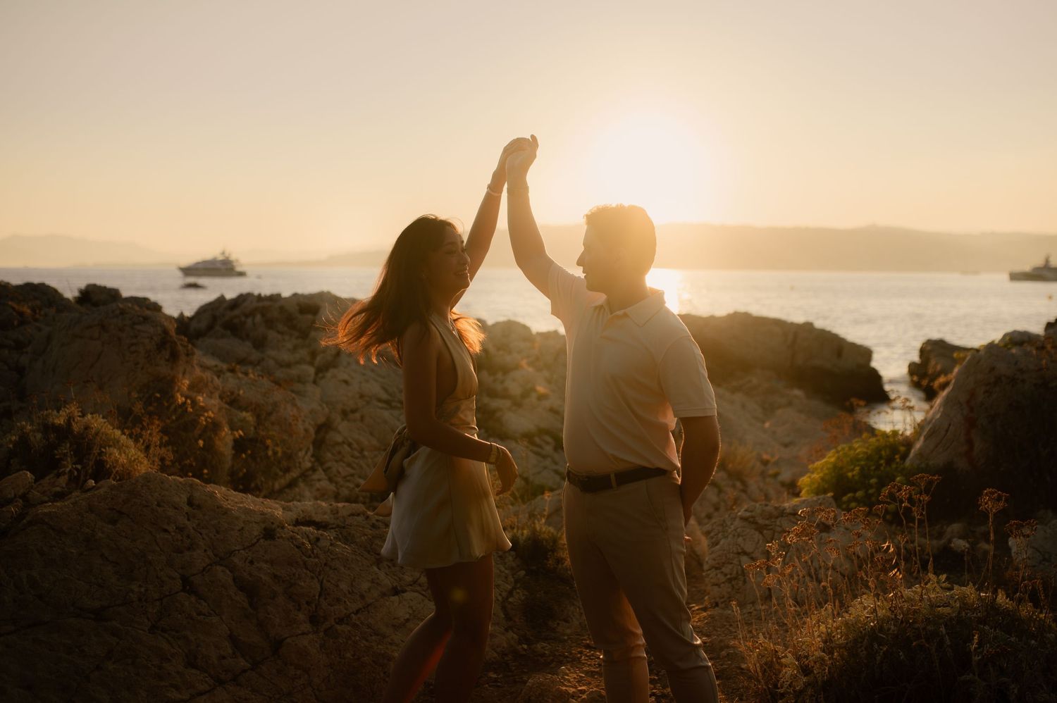 Photo d'un couple qui danse au coucher du soleil en bord de mer
