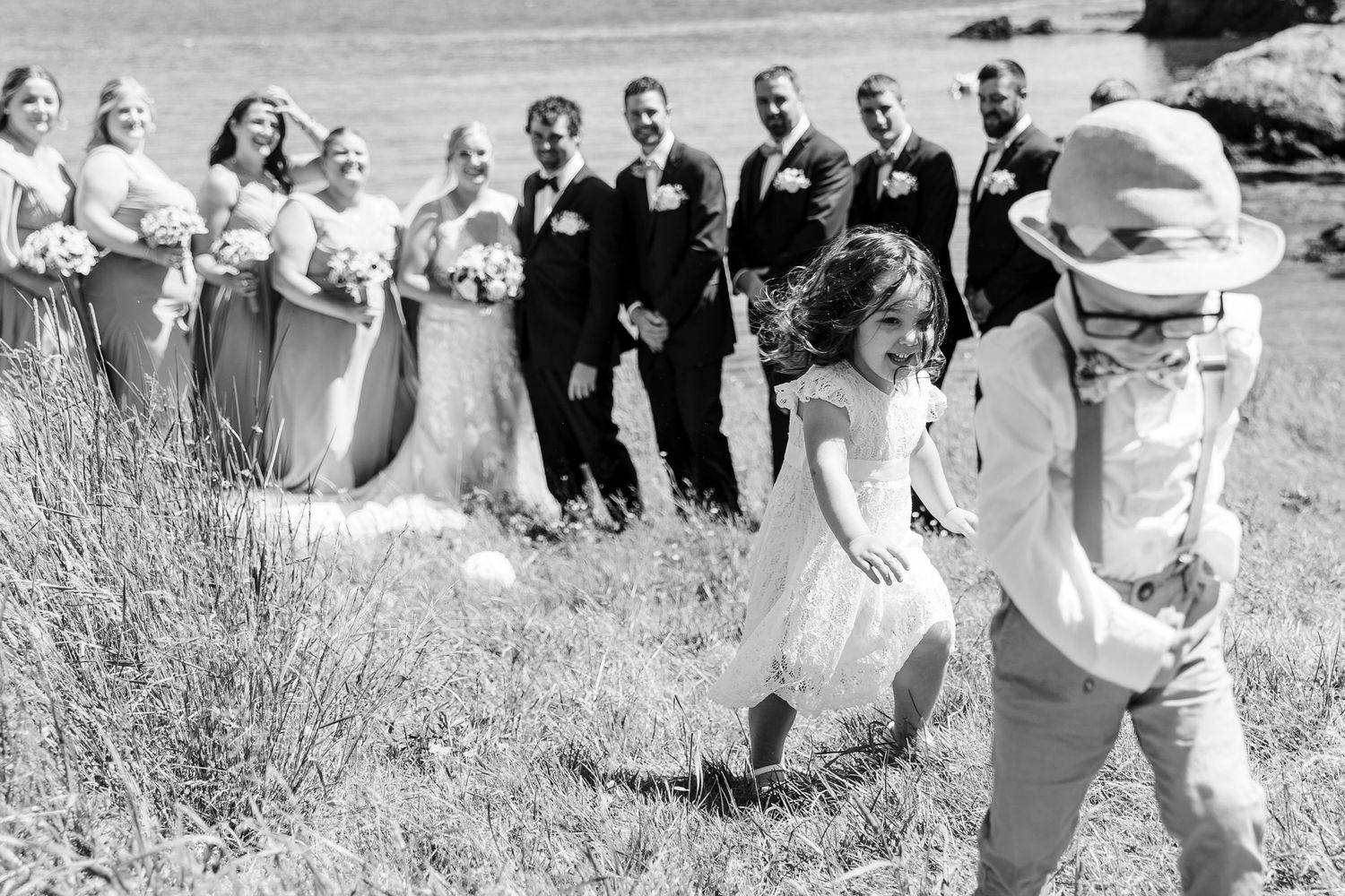 A group of wedding guests joins the bridal party for an energetic dance line outdoors during a celebration.