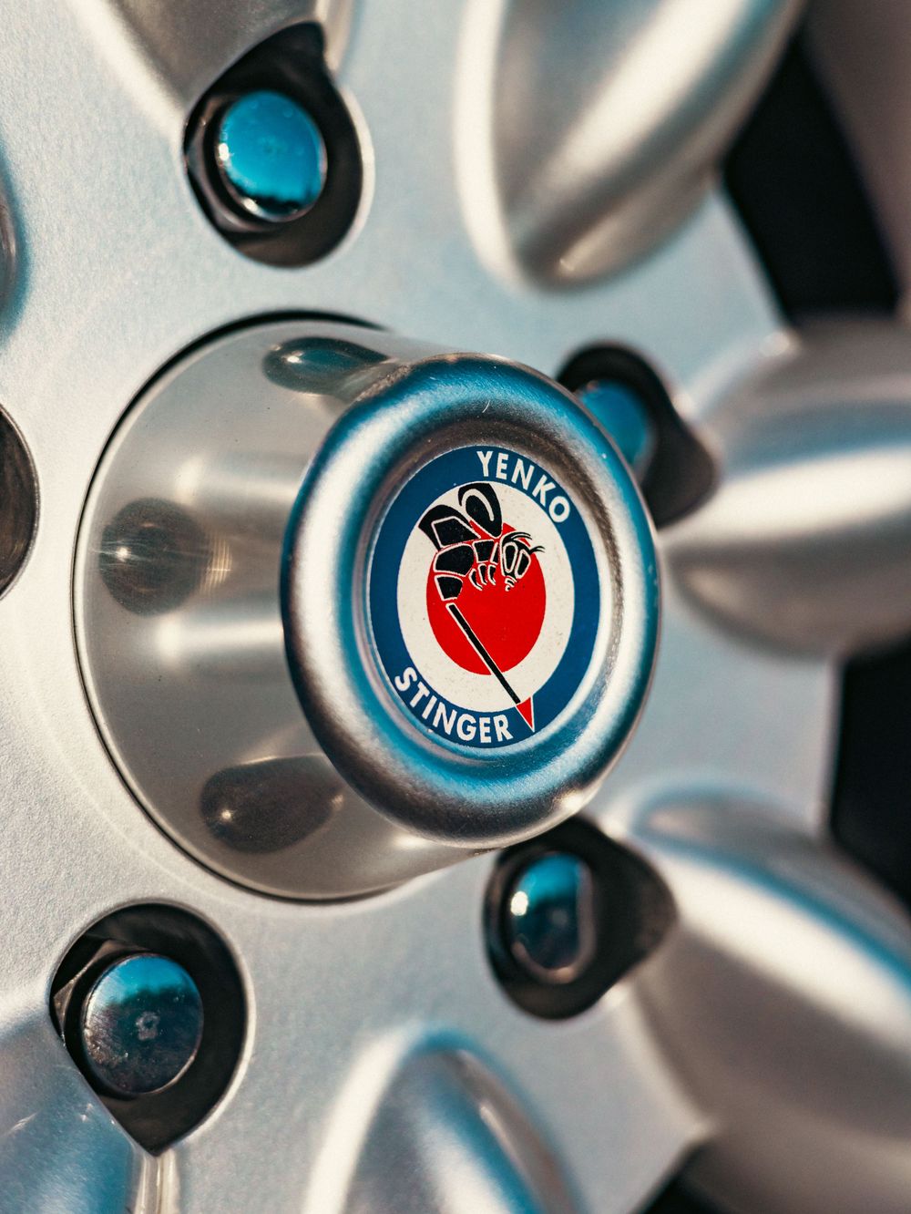 Close-up macro shot of Yenko Stinger wheel center cap with red shield logo.