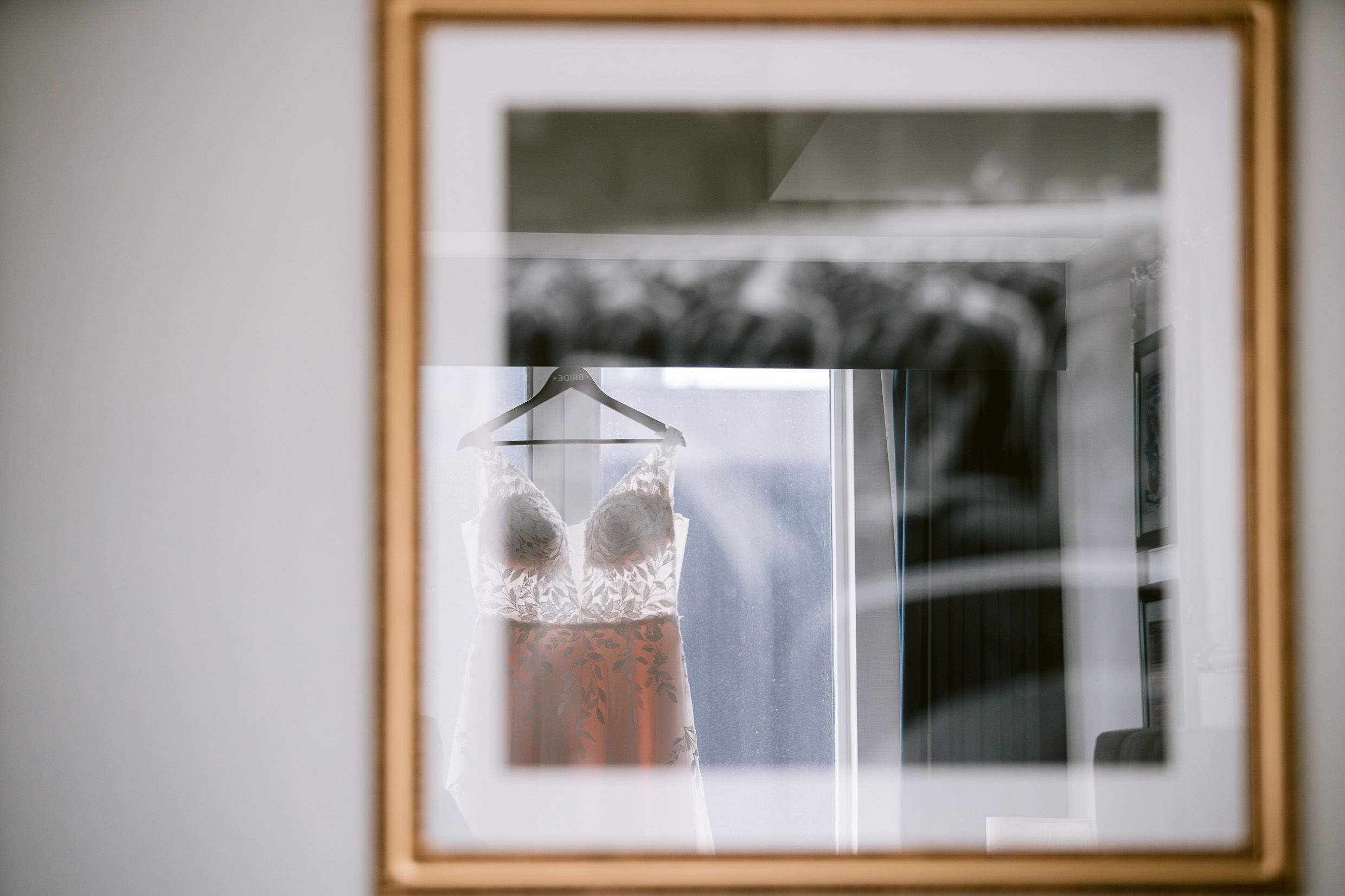 A framed wedding dress photograph with soft focus and delicate details in natural light.