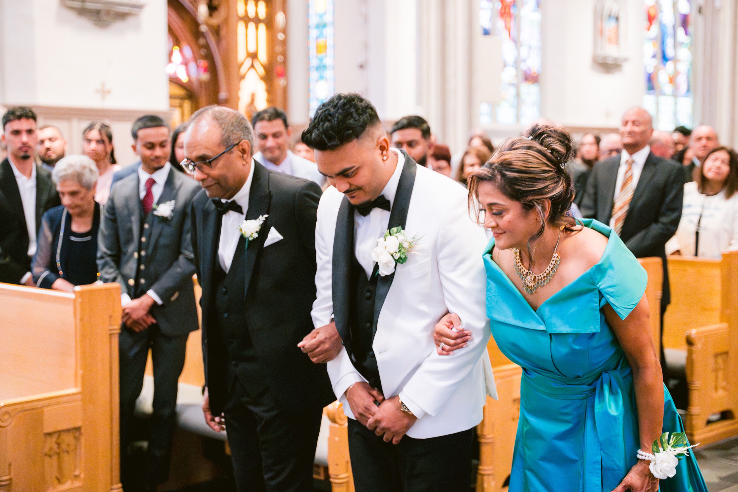People gathered in a church with stained glass windows during a special ceremony.