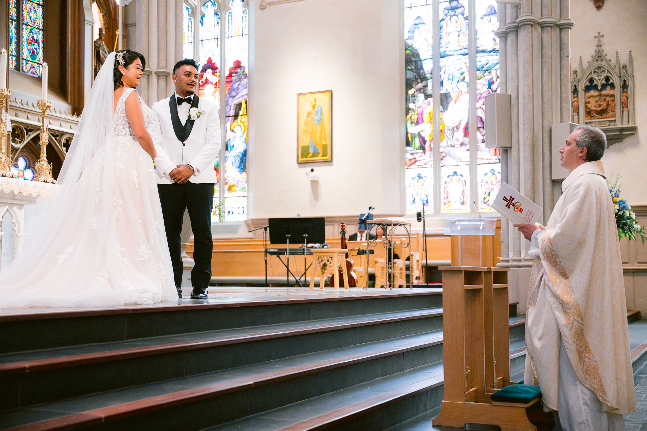 A traditional church wedding ceremony takes place with the couple and officiant at the altar.