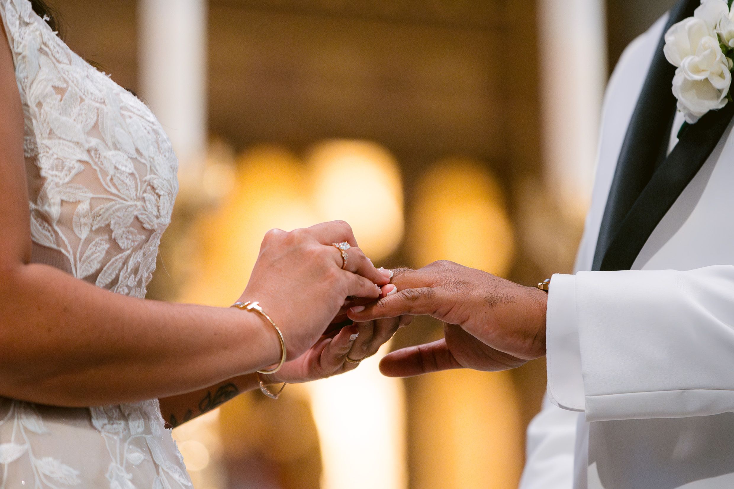 Close-up shot of bride and groom exchanging rings during wedding ceremony.