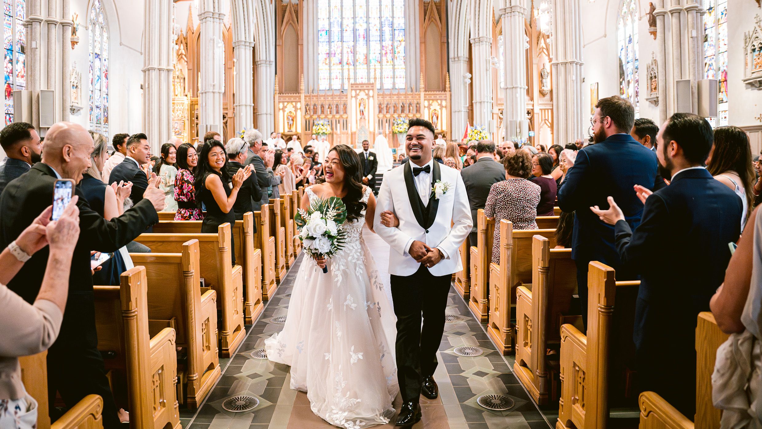 Wedding ceremony in a grand cathedral with elegant architectural details and stained glass windows.