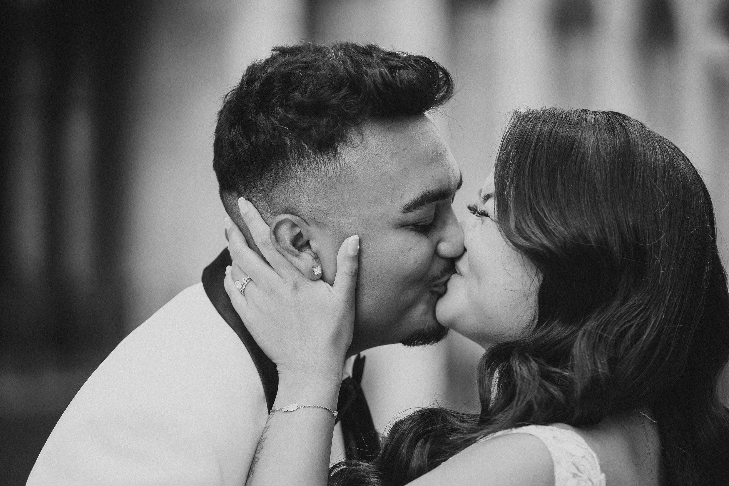 A romantic black and white portrait of a tender kiss between a couple showing intimate affection.