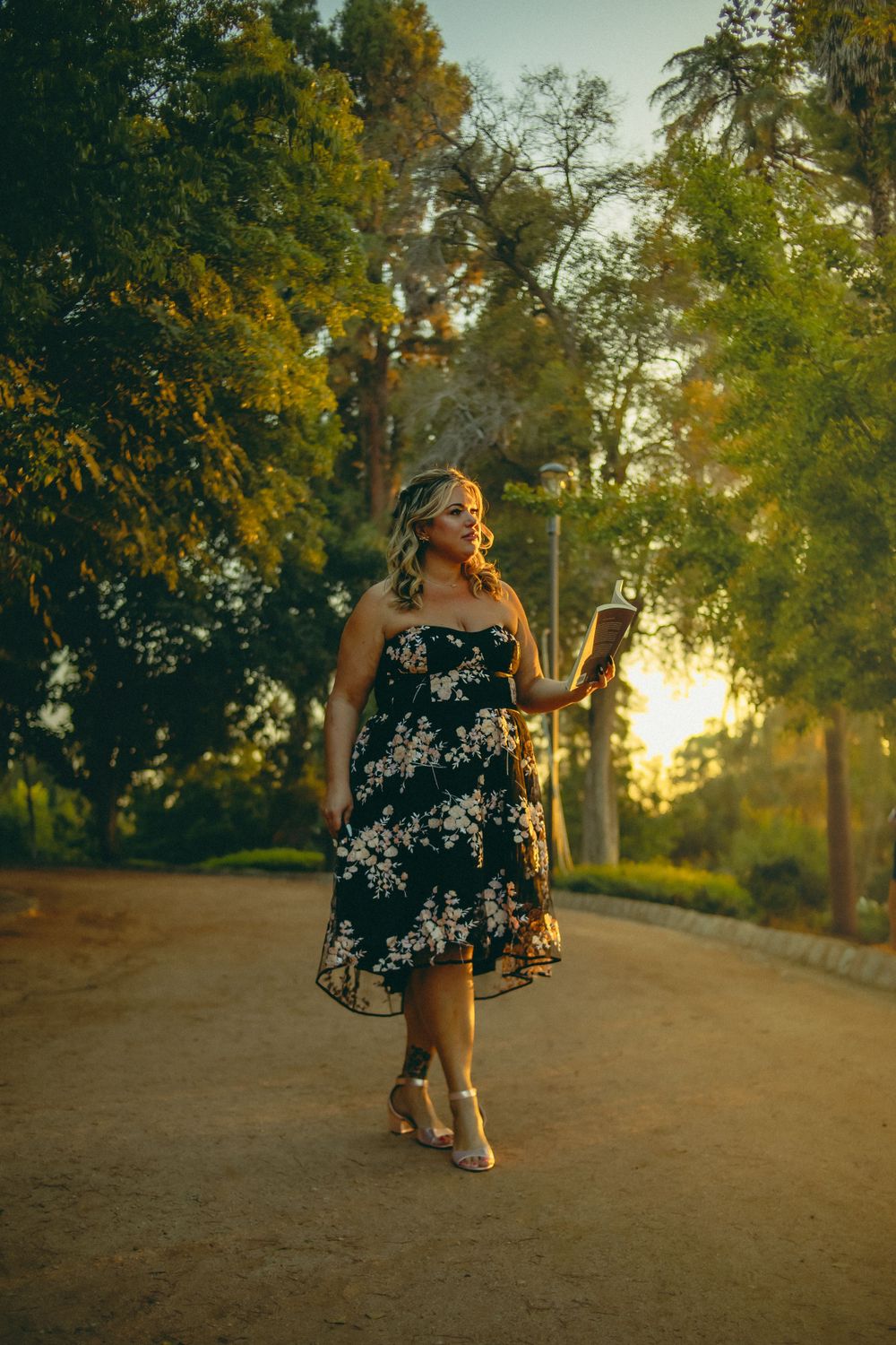 cinematic photograph of woman reading a book in the park