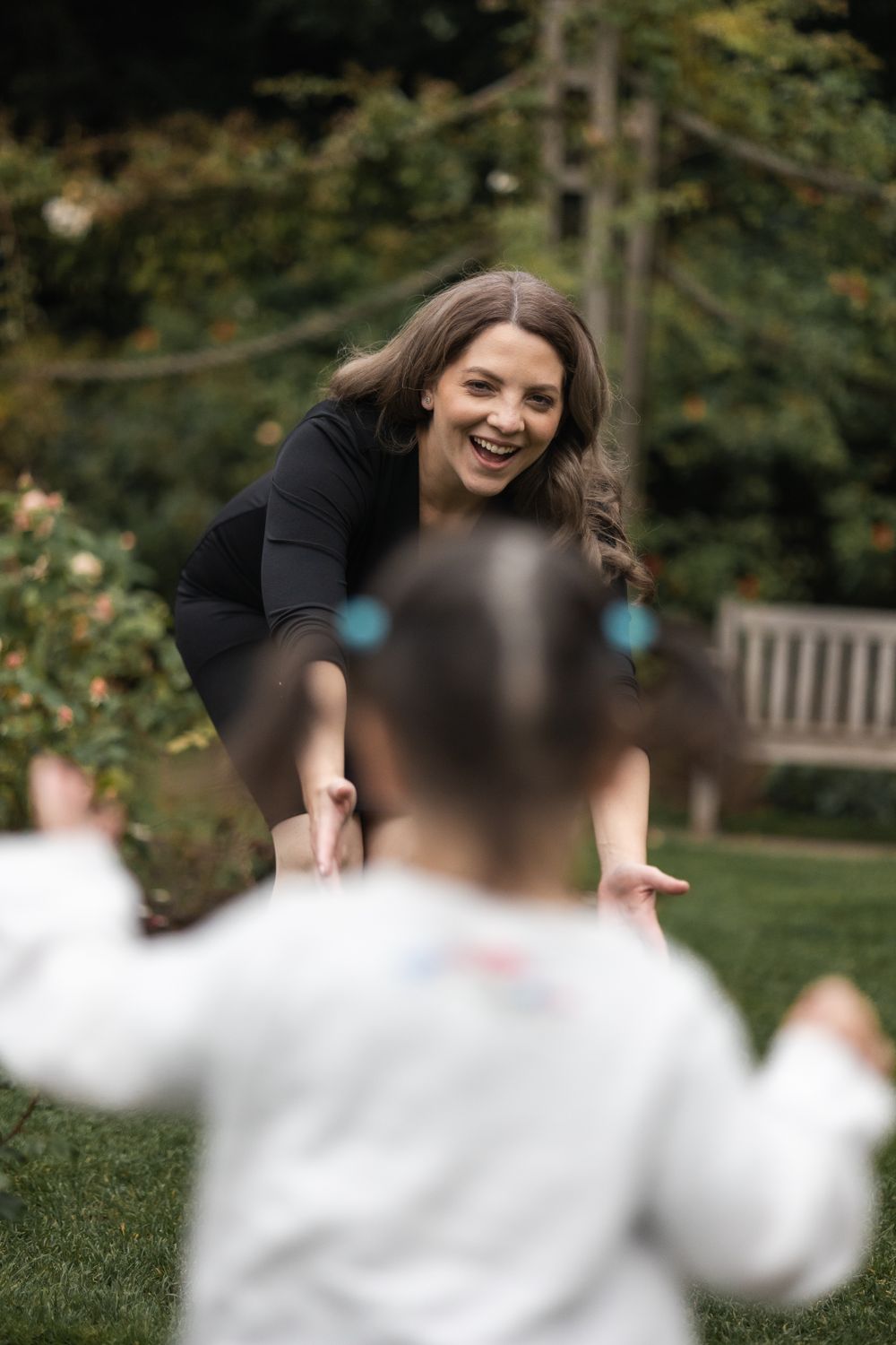 Little girl running towards her mum, who has open arms at relaxed outdoor photoshoot in central London.
