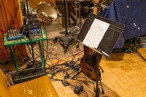 Wall mounted pedals and control units for musical equipment and effects processors are arranged in a studio setup.