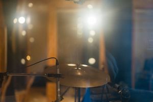 Professional microphone setup in a dimly lit recording studio with warm ambient lighting.