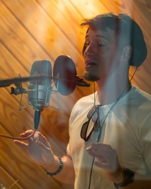 A passionate singer recording vocals with a professional microphone in a wood-paneled studio.