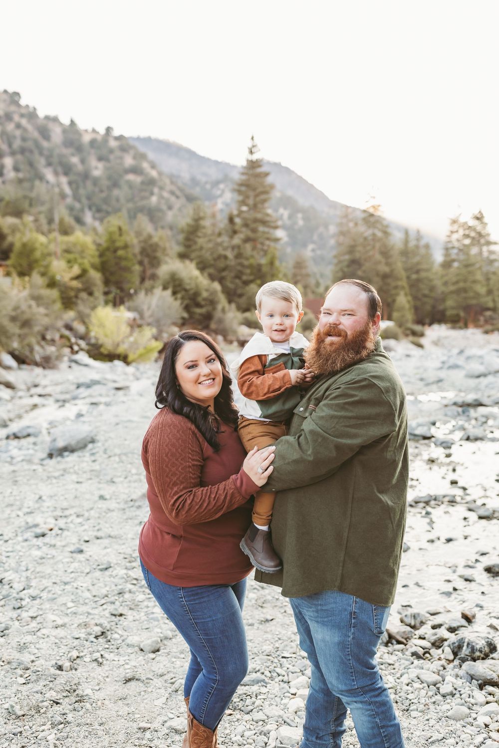A family enjoying an outdoor moment together on a rocky mountain trail during golden hour.