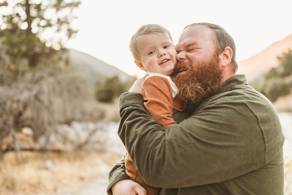 A heartwarming outdoor family moment captured during golden hour in a natural desert landscape setting.
