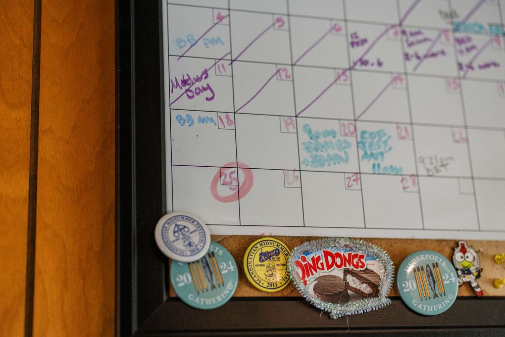 A wall calendar with decorative buttons or pins featuring vintage designs displayed along the bottom edge.