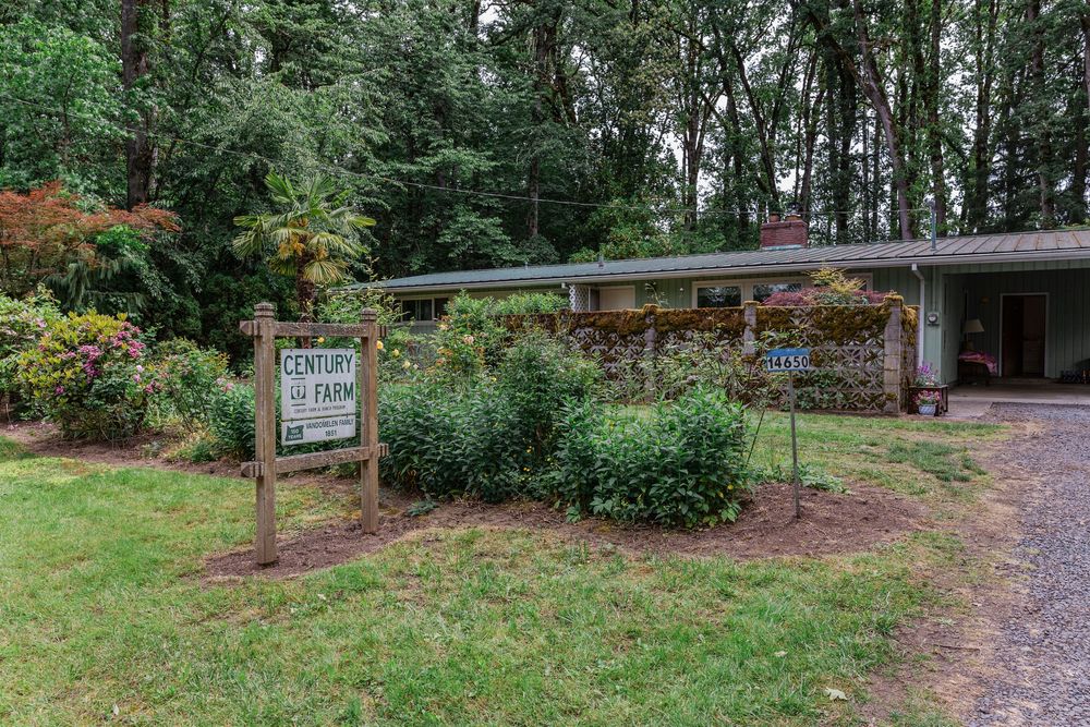 Modern ranch-style venue surrounded by lush greenery and decorated with colorful flowers.