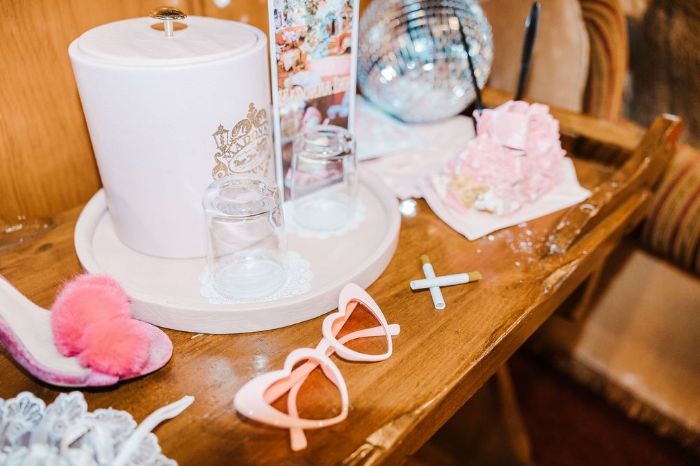 Pretty pink hair bows and decorative accessories arranged on a wooden table with a roll of white paper towels.