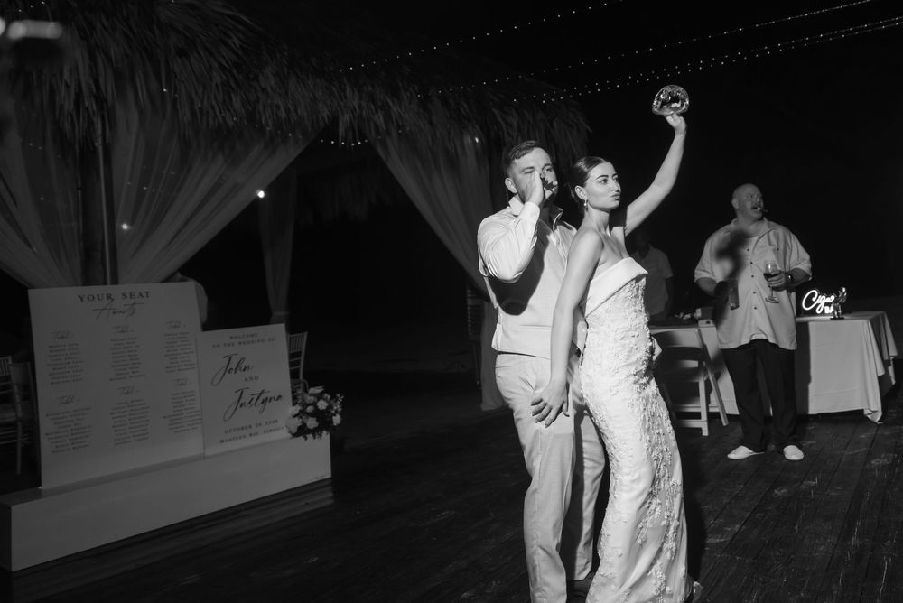 A wedding reception dancefloor scene with people in formal attire dancing and celebrating at night.