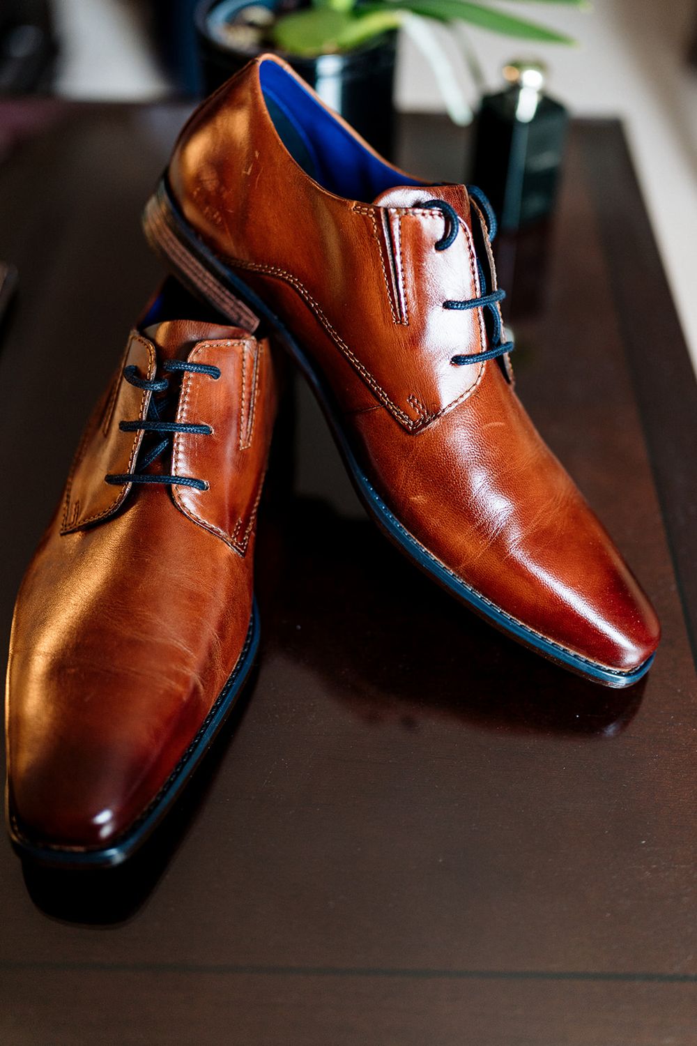 Close-up photos of brown leather dress shoes positioned at different angles showing their shiny polished finish.