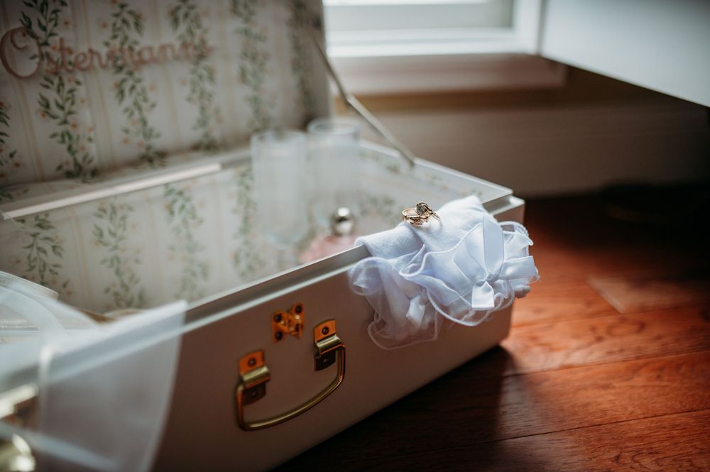 An elegant white molded baseboard trim against floral wallpaper in a traditional style room interior.