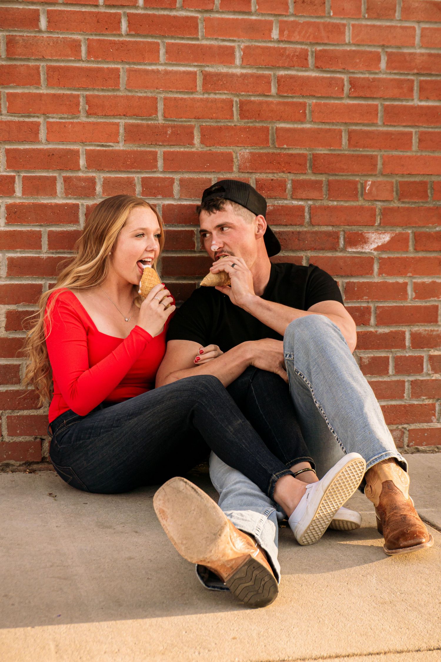 Colorado Springs Engagement Photographer. Couple sitting outside and eating ice cream on the ground during golden hour.