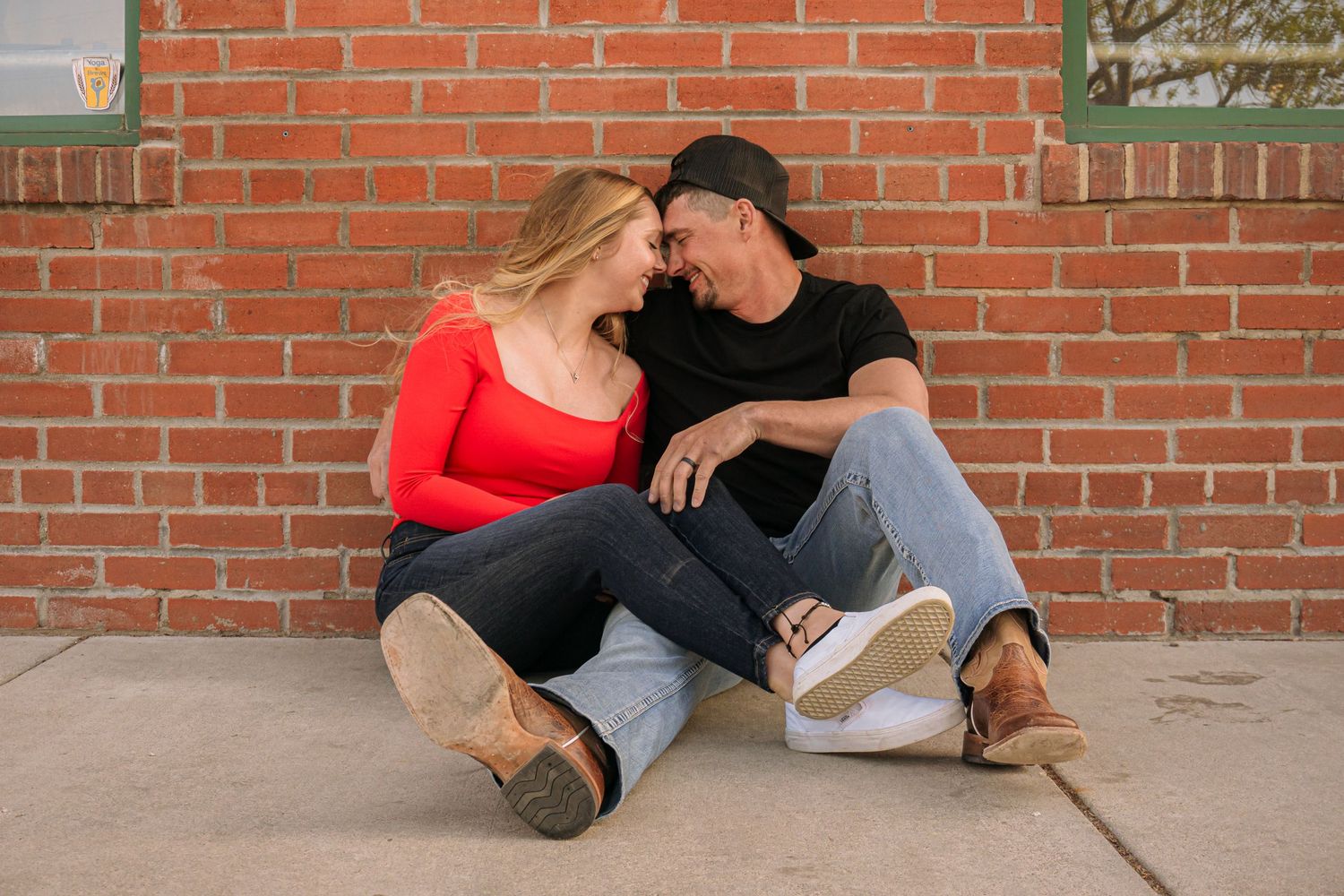 Colorado Springs Engagement Photographer. Couple sitting outside on the ground during golden hour.