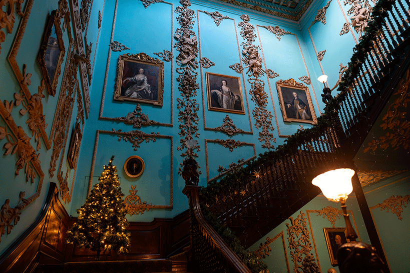 Staircase of Powderham Castle in Devon with bright blue walls