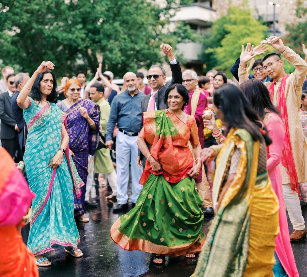 Guests in vibrant saris dancing during an outdoor celebration.