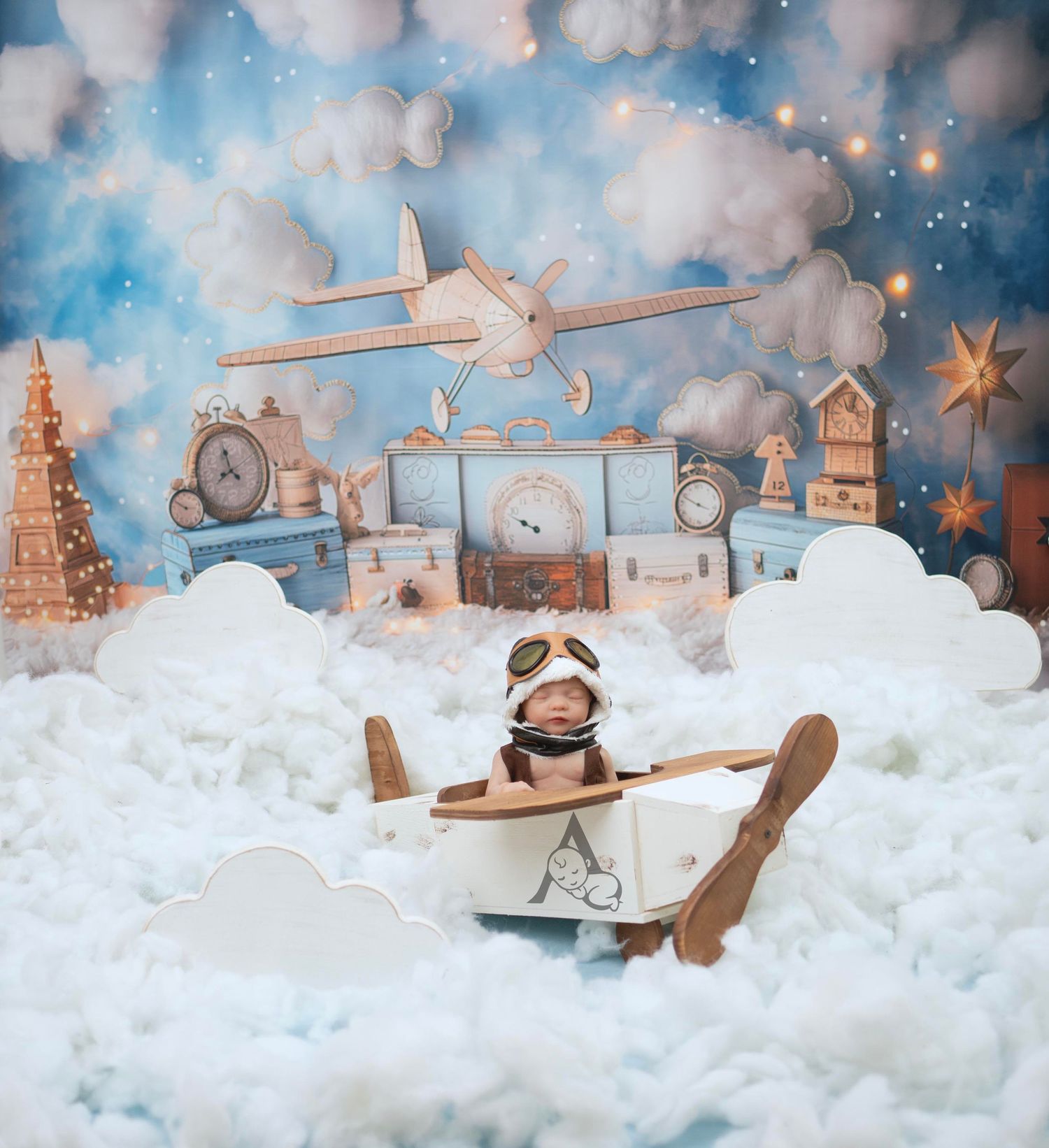 Whimsical winter scene with toy airplane and prop decorations among cotton clouds and twinkling lights.