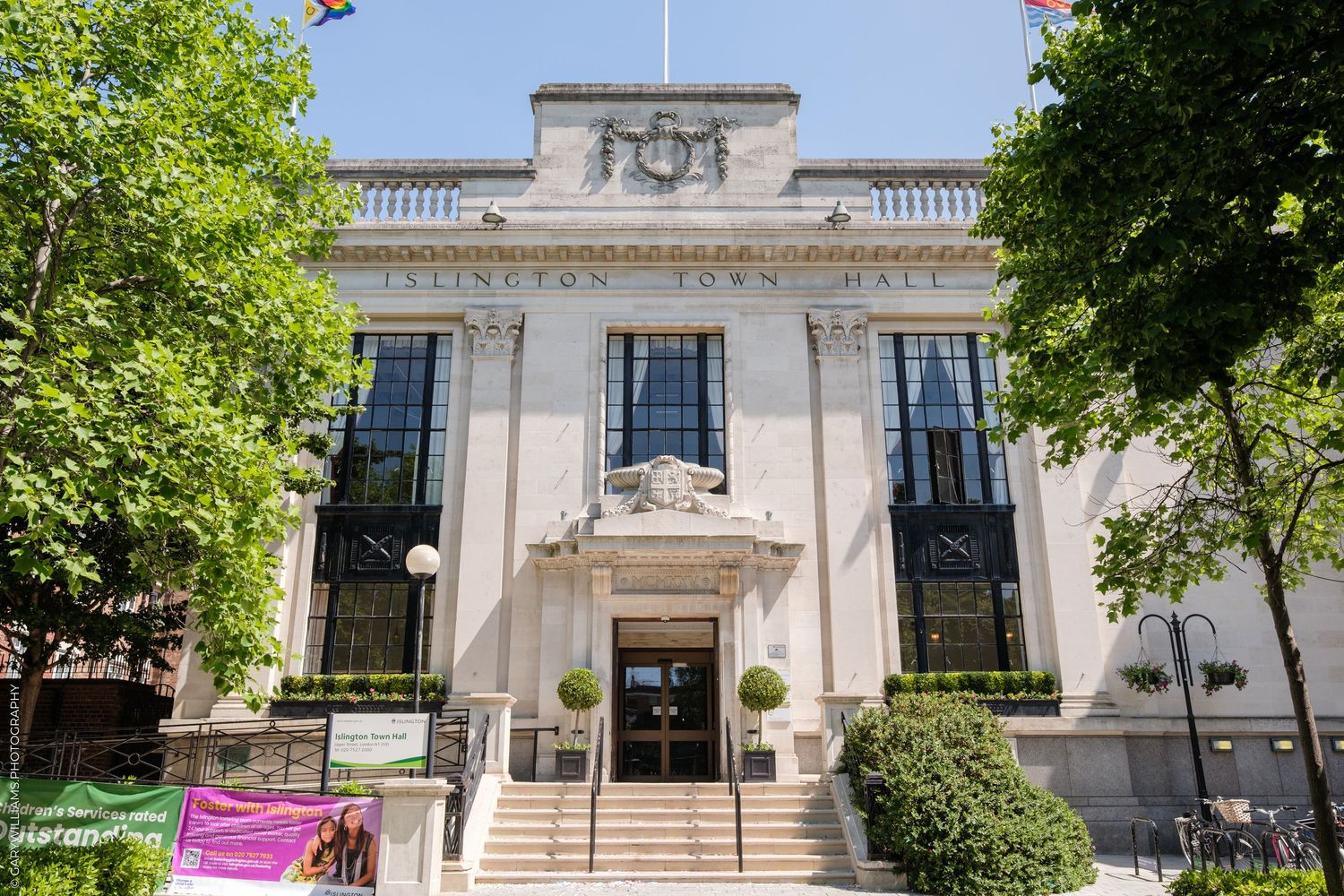 Stately white stone neoclassical municipal building exterior with tall windows and ornate architectural details.
