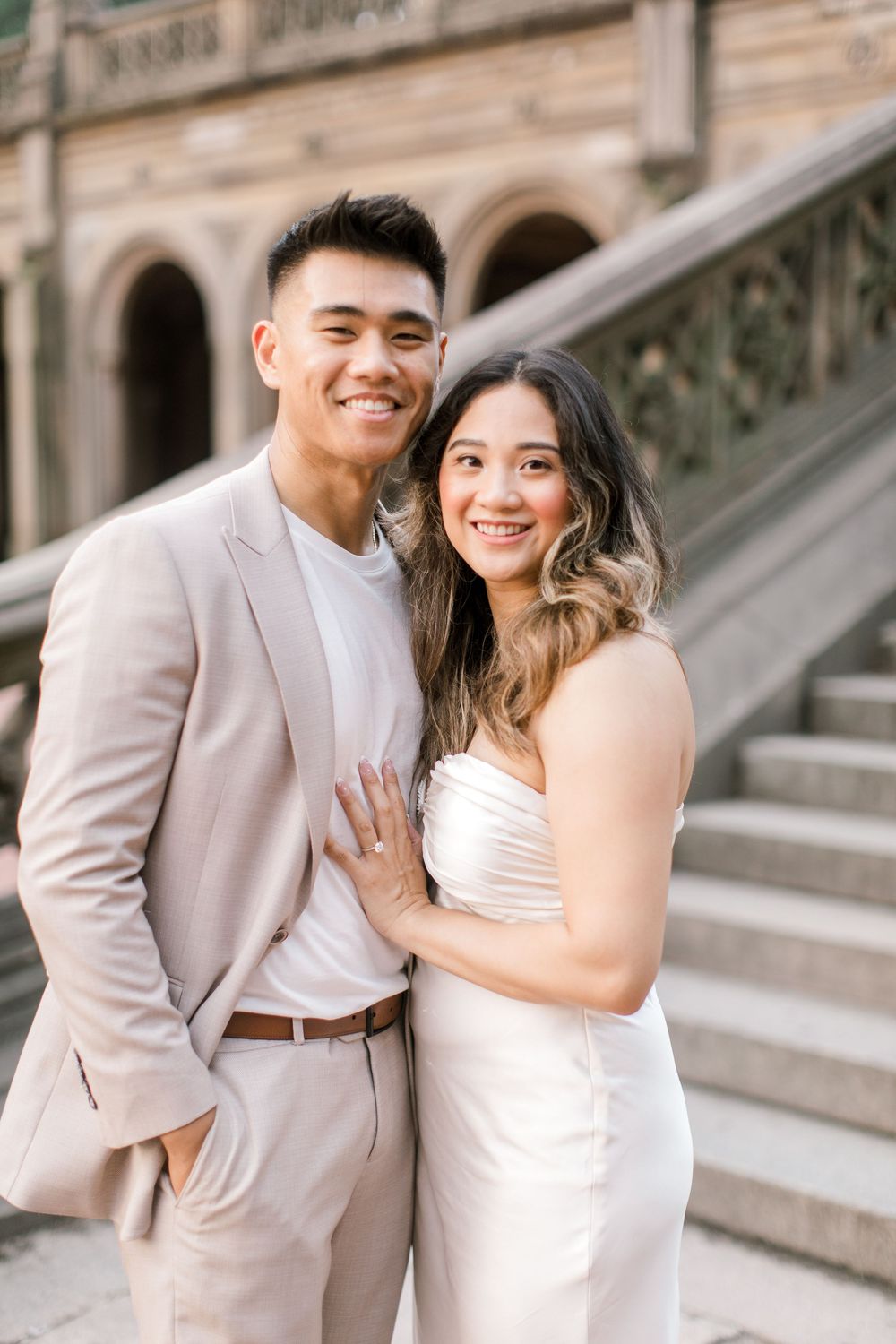 Engaged couple sharing a romantic moment by the iconic Bethesda Fountain in NYC.