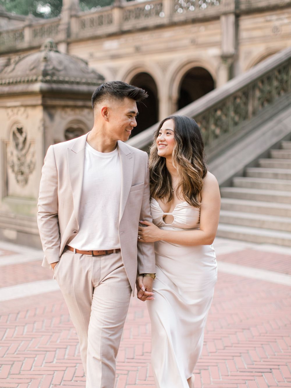 Engaged couple sharing a romantic moment by the iconic Bethesda Fountain in NYC.