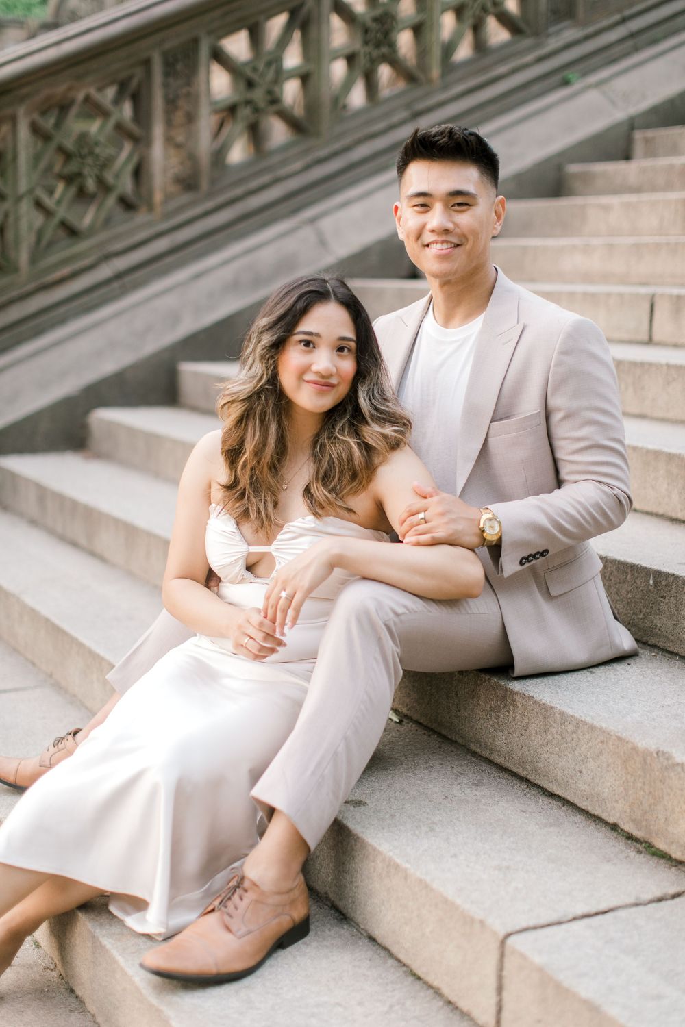 Engaged couple sharing a romantic moment by the iconic Bethesda Fountain in NYC.