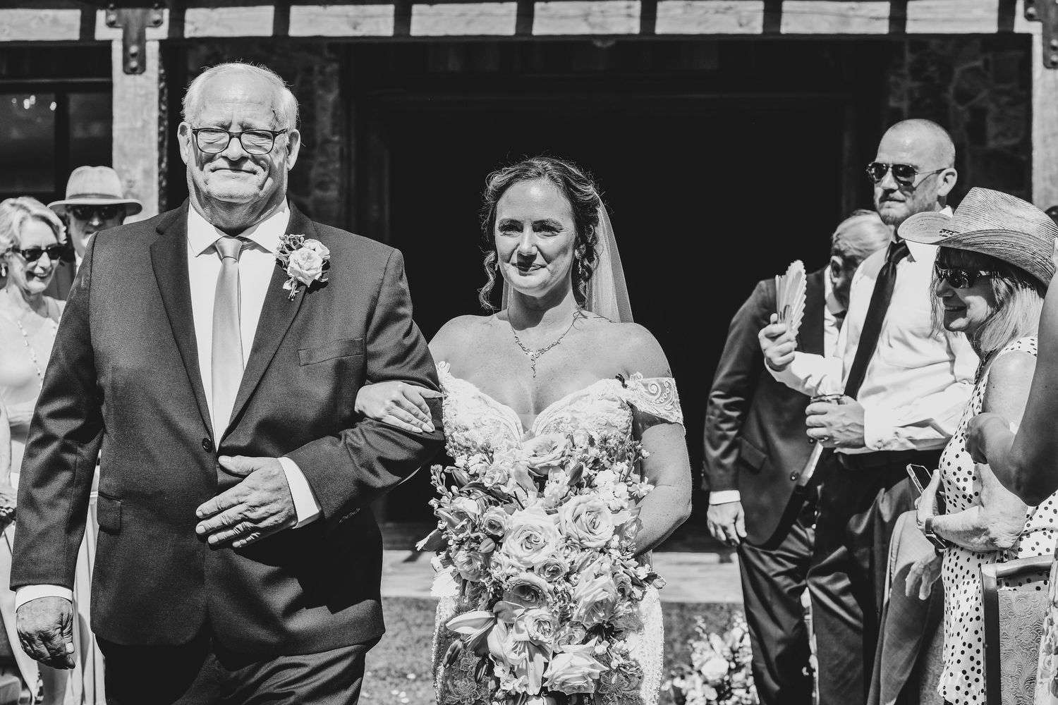 Bride walking down the aisle at Hotel Drover courtyard with soft blush and ivory bouquet
