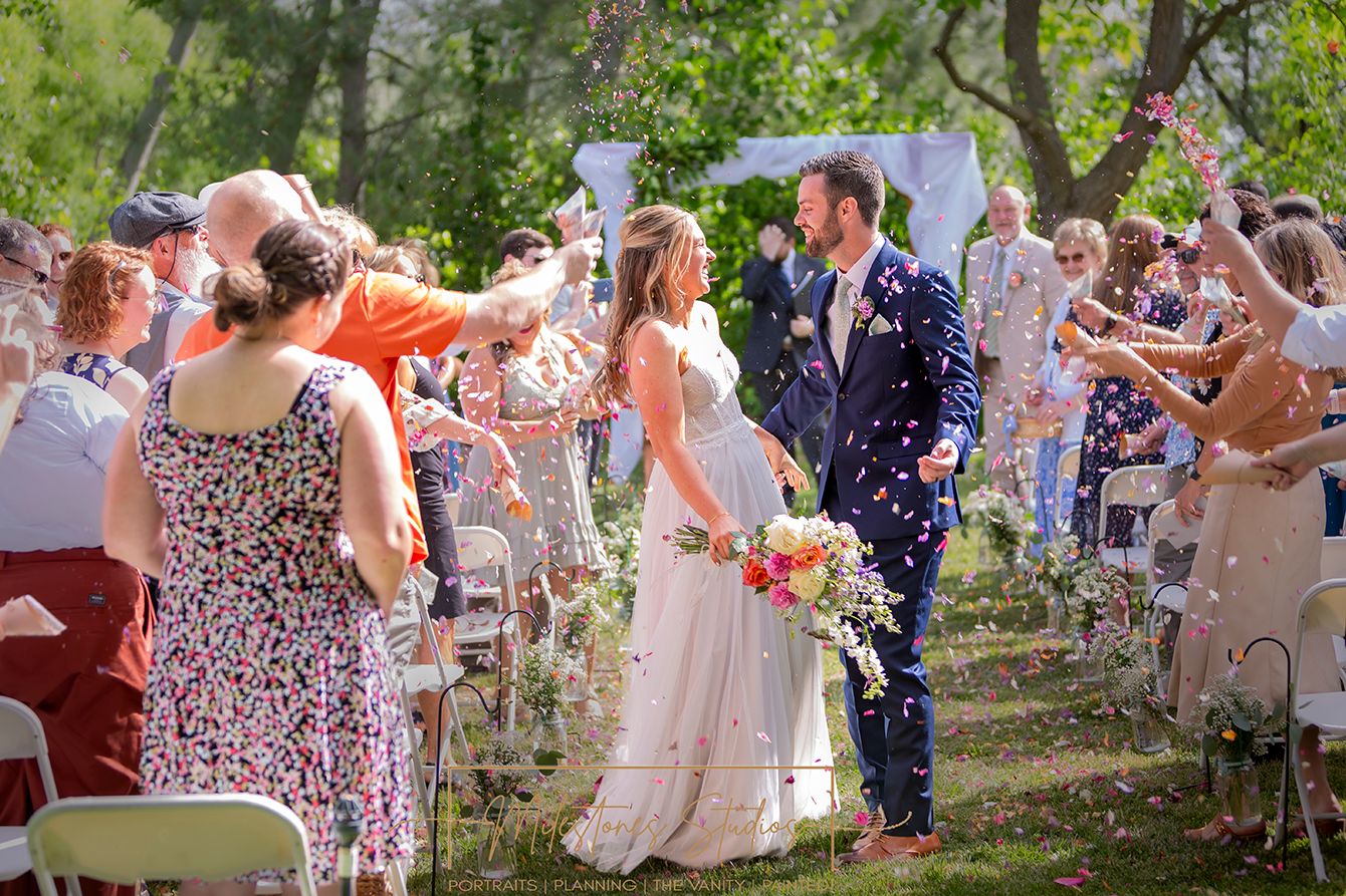 bride and groom walking up aisle celebrating everyone throwing flower petals