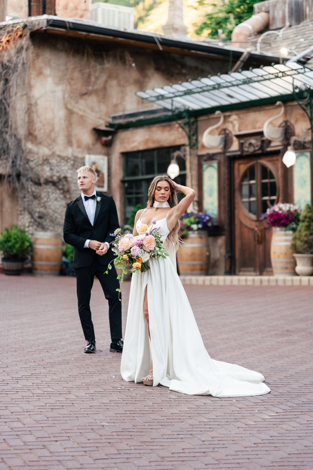A series of wedding photos showing a couple walking across a stone paved courtyard in formal attire.